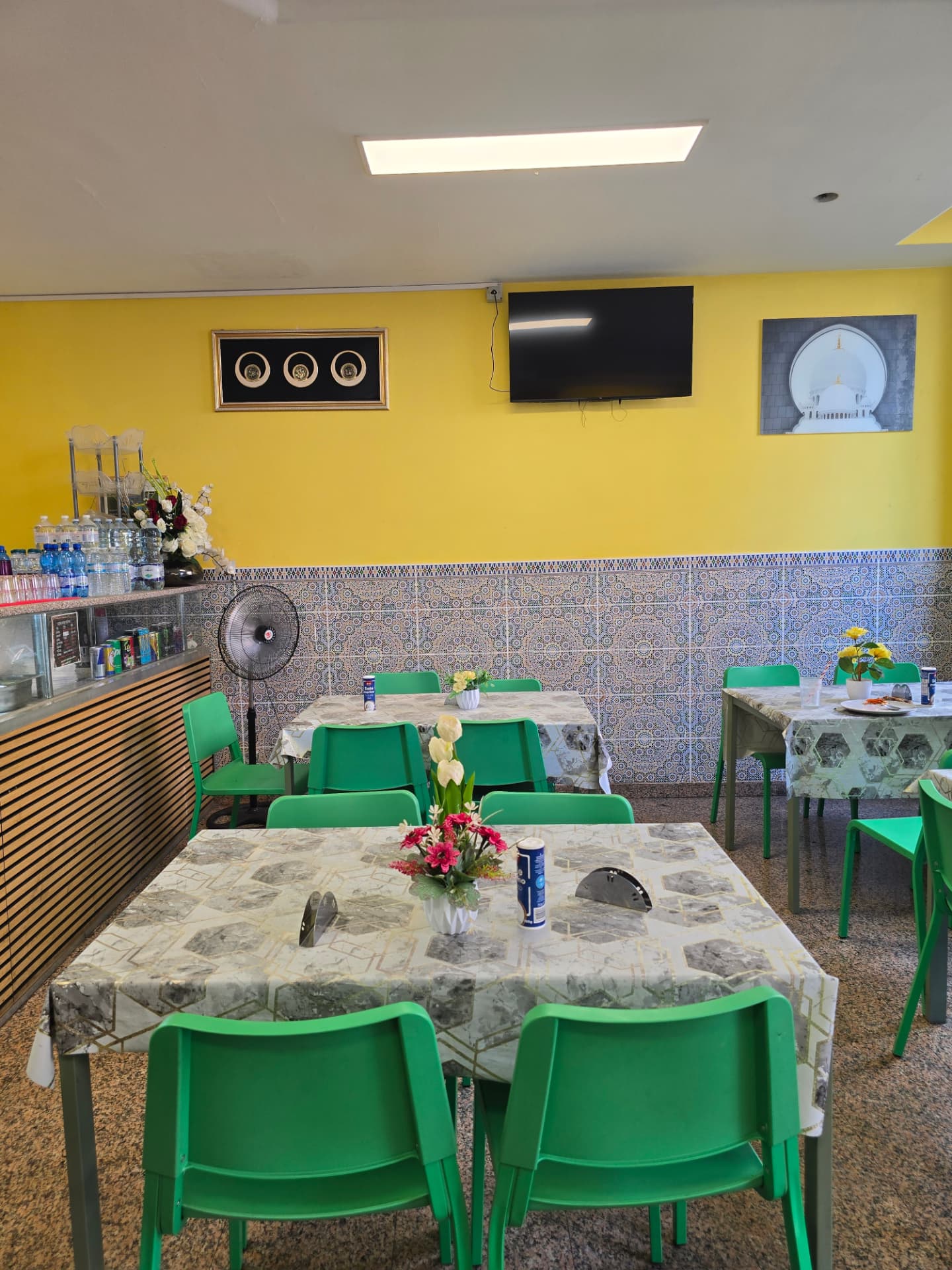 Bismillah Bangla Restaurant — bright yellow dining area with green chairs